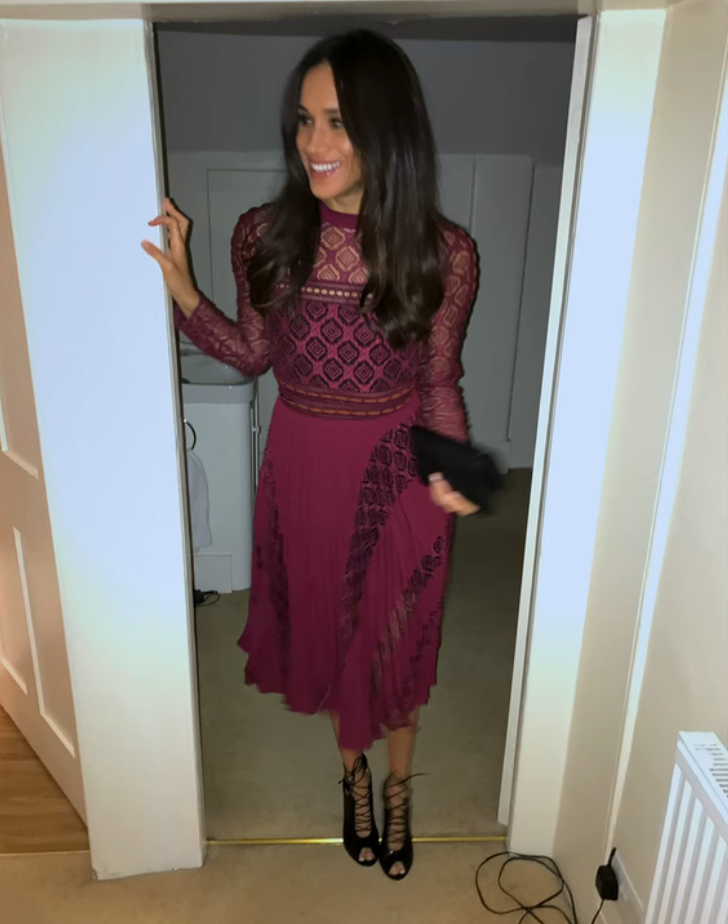 Meghan Markle wears burgundy Self-Portrait ‘Symm’ dress and black Gianvito Rossi ‘Julia’ lace up booties.