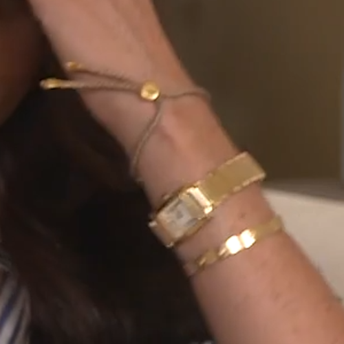 Meghan Markle wears Cartier 'Love' Yellow Gold Bracelet, Monica Vinader ​Linear Friendship Bracelet (repeats), and Princess Diana's gold Cartier tank française watch for FORTUNE MPW interview